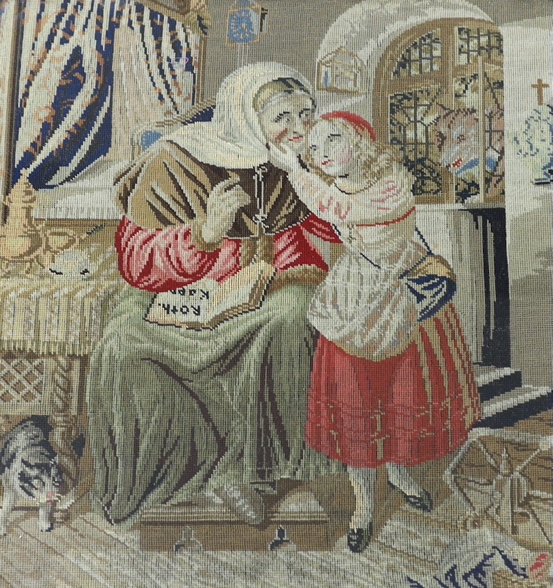 A 19th century gilt-framed petit point figural interior scene, 35 cms wide x 37 high.